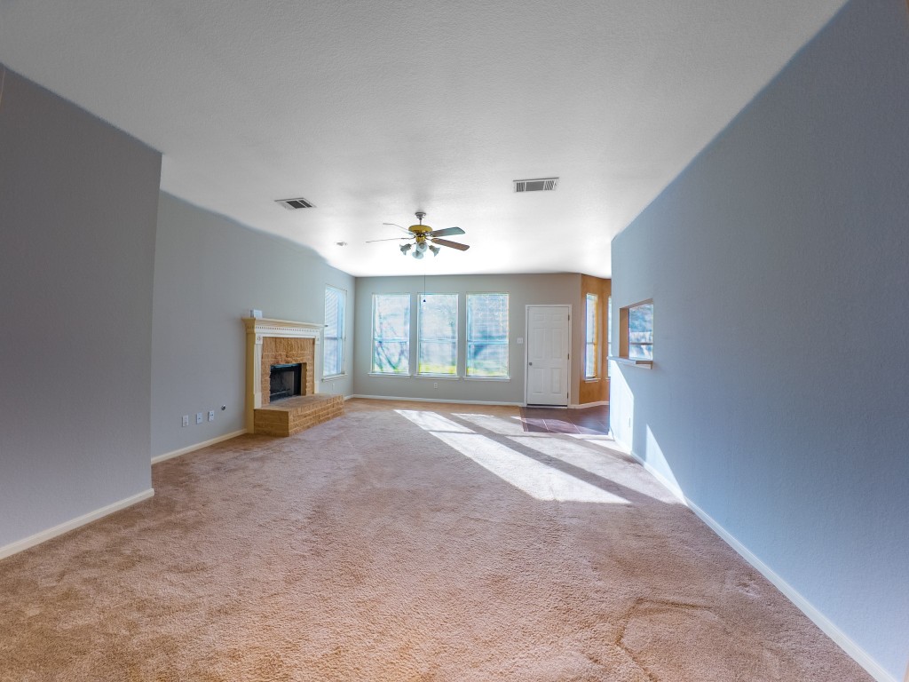1706 Apache Trail Round Rock, TX 78665 - Photo 15 of 40 Unfurnished living room featuring a fireplace, carpet floors, and ceiling fan