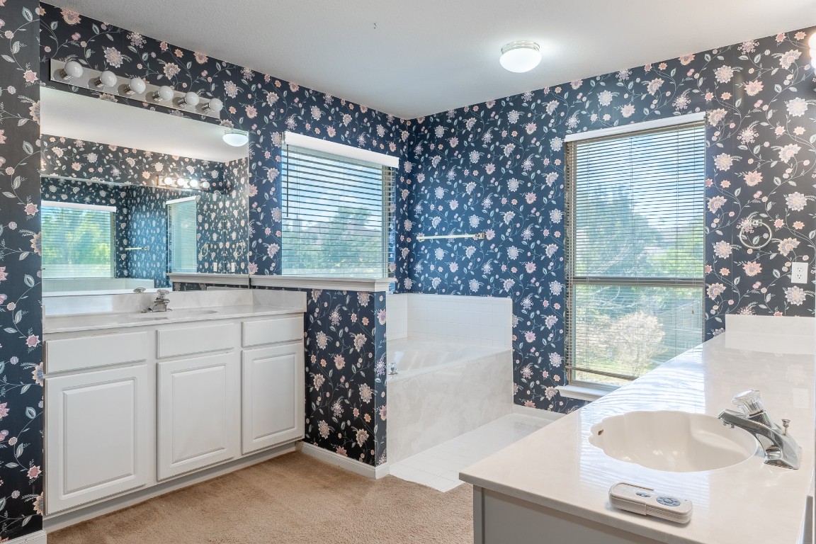 1706 Apache Trail Round Rock, TX 78665 - Photo 19 of 40 Bathroom featuring wallpapered walls, two vanities, a bath, and plenty of natural light