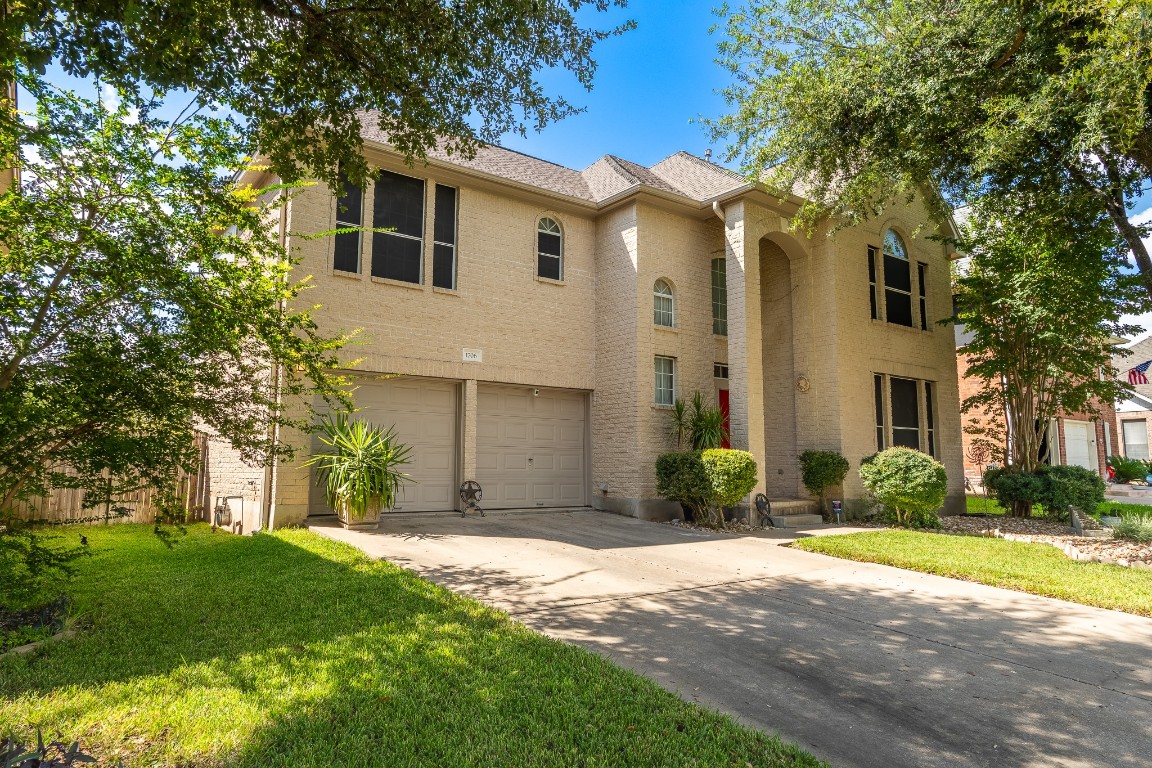 1706 Apache Trail Round Rock, TX 78665 - Photo 2 of 40 Traditional-style house featuring concrete driveway, a garage, brick siding, and a front lawn