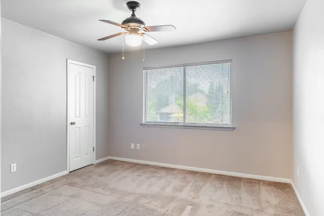 a view of a hallway with wooden floor and a bathroom