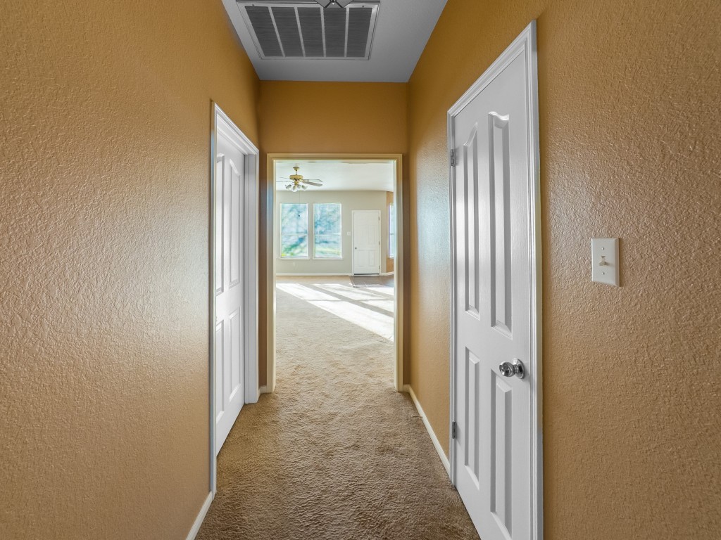 1706 Apache Trail Round Rock, TX 78665 - Photo 30 of 40 Hallway with a textured wall and carpet floors