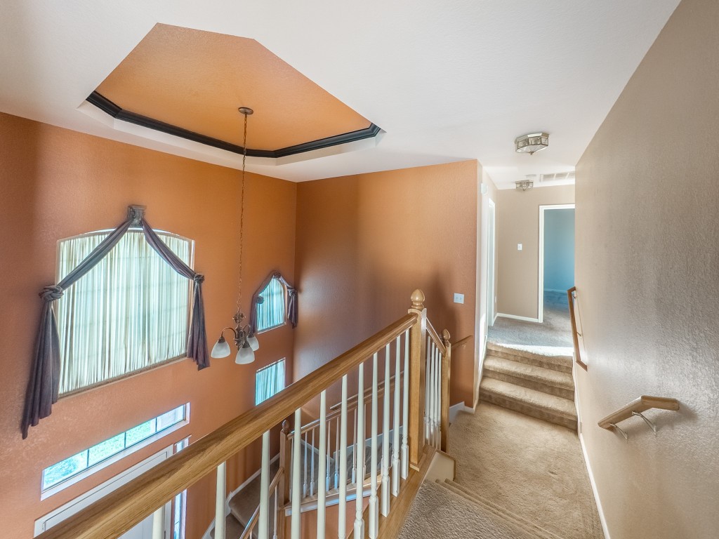 1706 Apache Trail Round Rock, TX 78665 - Photo 33 of 40 Stairway with a raised ceiling, carpet floors, and a chandelier