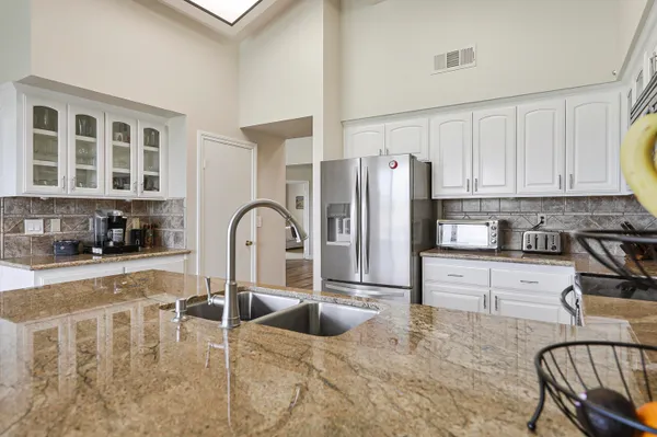 a kitchen with stainless steel appliances granite countertop a stove a refrigerator a stove a dining table and chairs with wooden floor