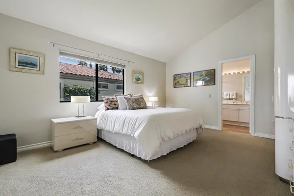 a spacious bedroom with a bed and a large window