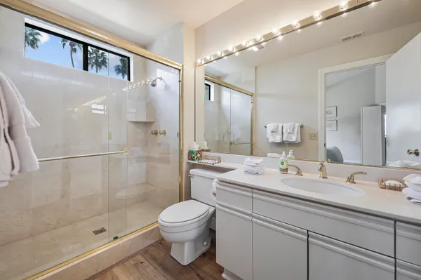 a bathroom with a sink a toilet and shower