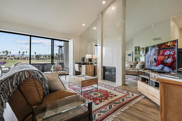a living room with furniture a rug and a floor to ceiling window