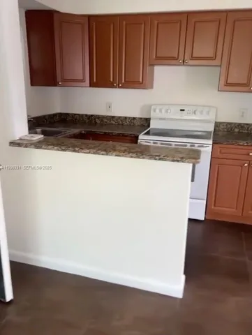 a kitchen with stainless steel appliances granite countertop a refrigerator a stove a sink and dishwasher with wooden floor