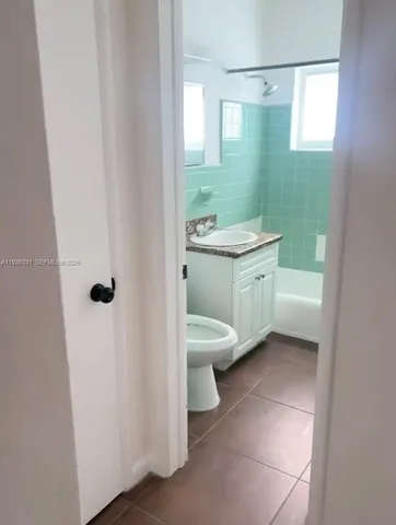 a bathroom with a granite countertop sink a toilet and a mirror