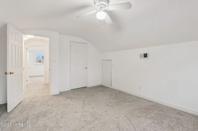 an empty room with fan and entrance