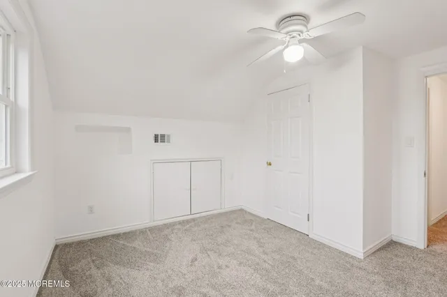 an empty room with a ceiling fan and a window