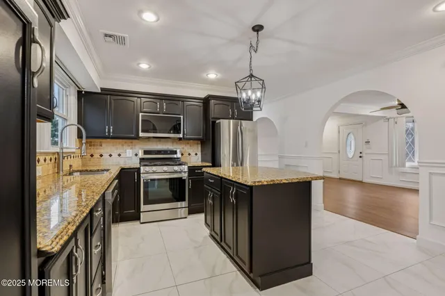 a kitchen with stainless steel appliances granite countertop a stove and a refrigerator