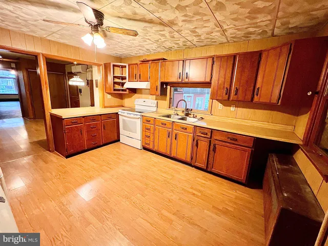 a kitchen with stainless steel appliances granite countertop a sink a stove and a refrigerator