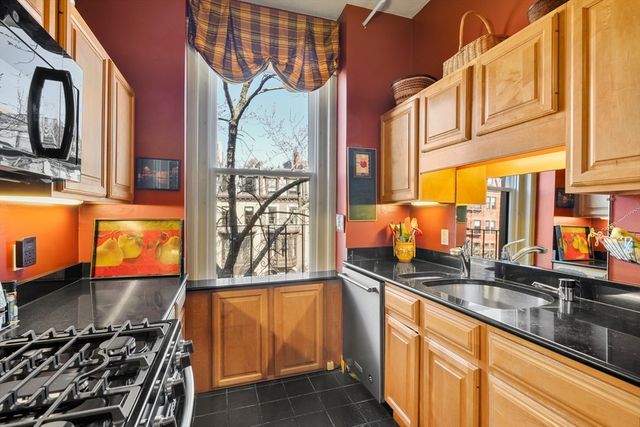 a kitchen with stainless steel appliances a sink a stove and a window