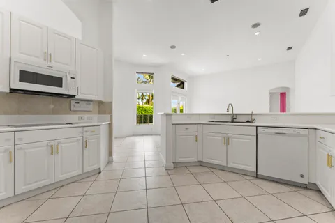 a kitchen with white cabinets a sink and appliances