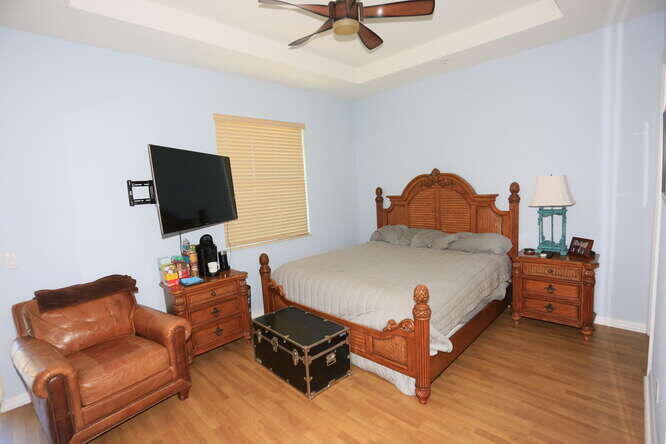 4159 Main Street Jupiter, FL 33458 - Photo 17 of 39 a bedroom with bed and a flat tv screen on dresser