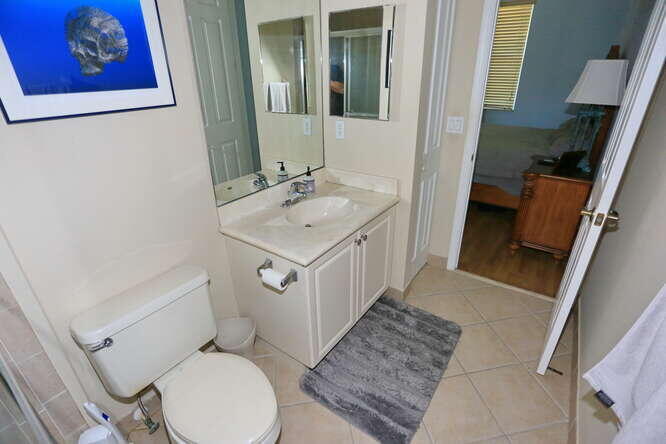 4159 Main Street Jupiter, FL 33458 - Photo 21 of 39 a bathroom with a toilet sink and mirror