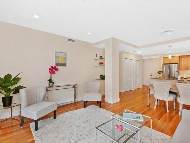 a living room with furniture and a dining table with kitchen view
