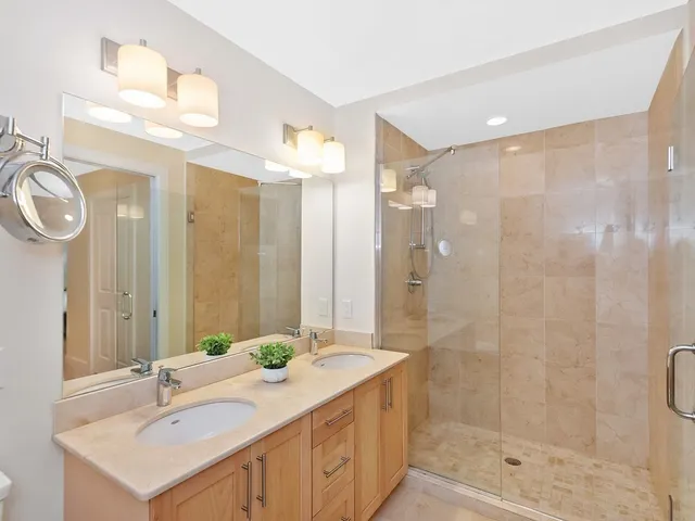 a bathroom with a shower sink and mirror