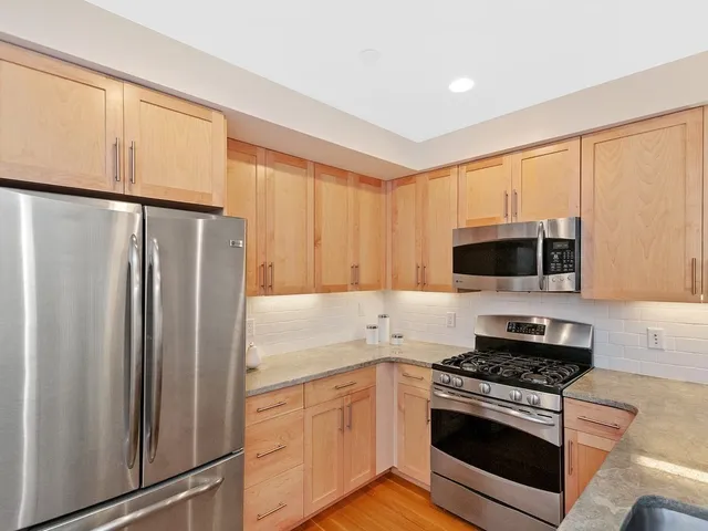 a kitchen with stainless steel appliances granite countertop a refrigerator stove and microwave