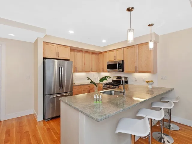 a kitchen with stainless steel appliances granite countertop a sink refrigerator and microwave