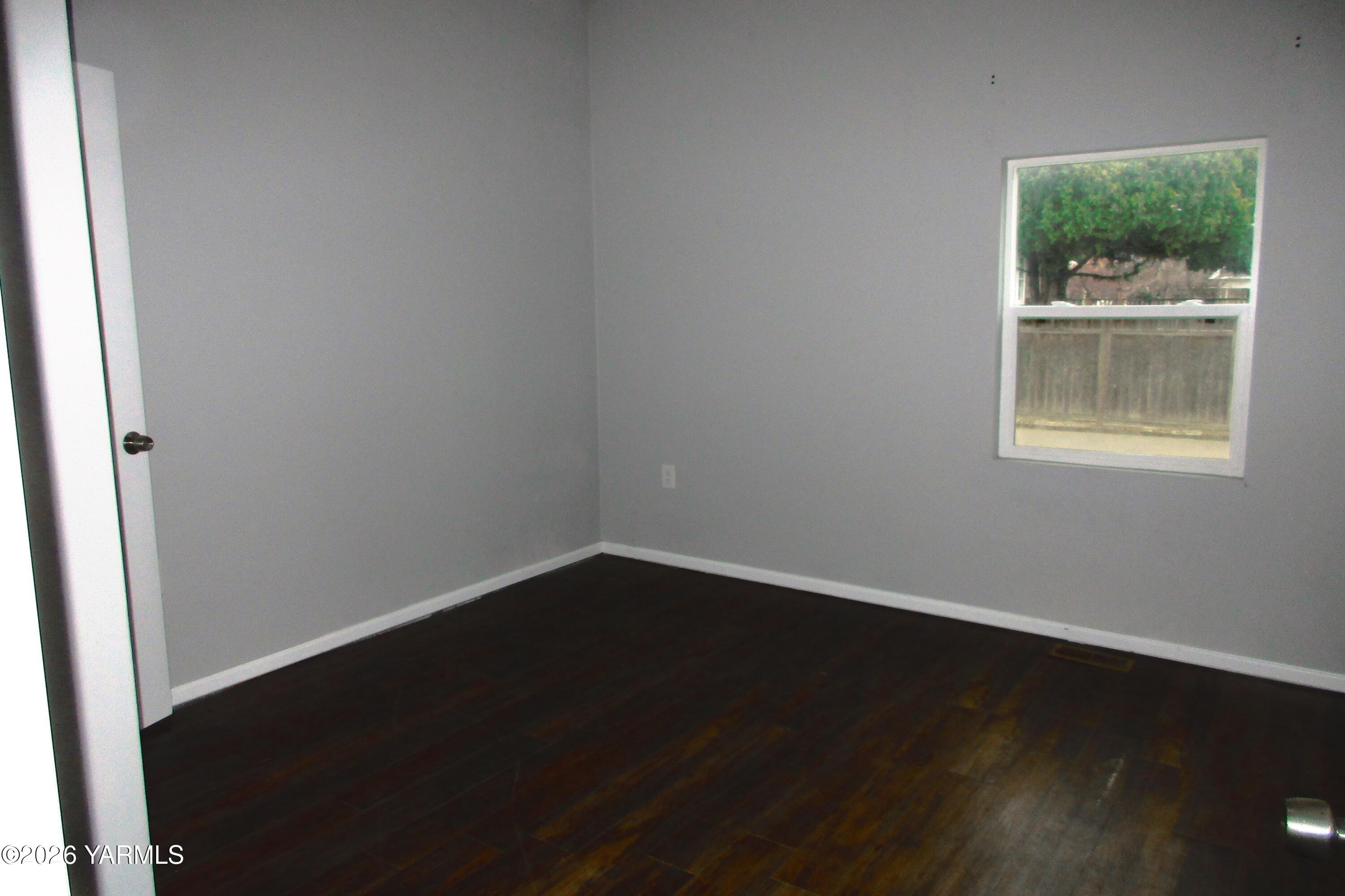 208 North Alder Street Toppenish, WA 98948 - Photo 11 of 14 an empty room with wooden floor and windows
