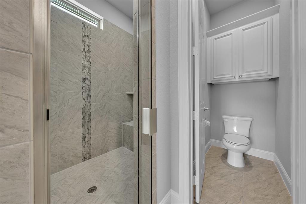 1060 Waters Edge Court Oak Point, TX 75068 - Photo 29 of 40 a bathroom with a toilet and a shower