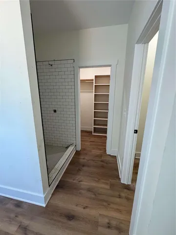 a view of a hallway with wooden floor and staircase