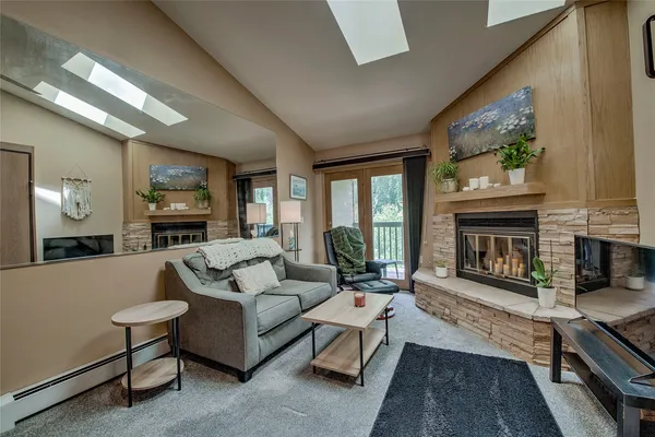 a living room with furniture a fireplace a large window and a flat screen tv