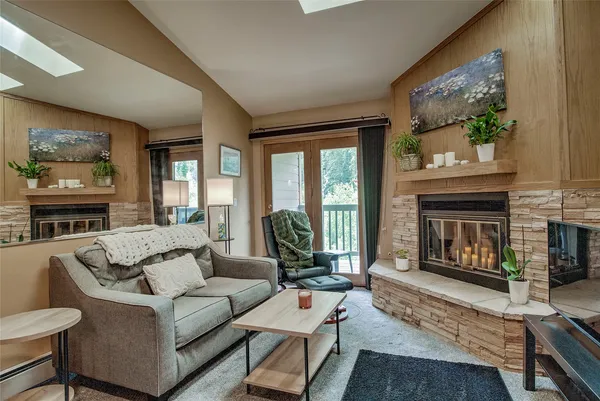 a living room with furniture a fireplace and a large window