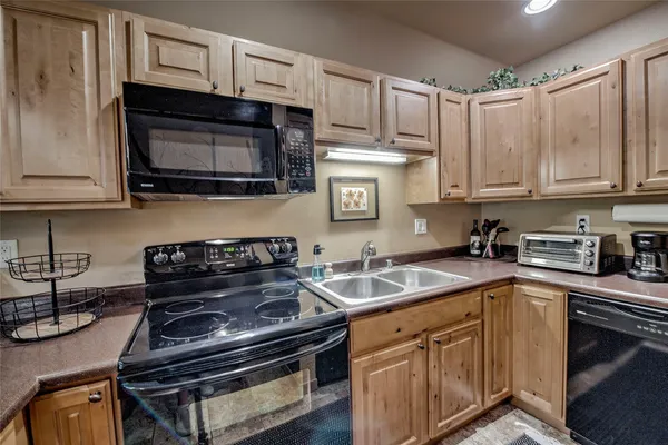 a kitchen with stainless steel appliances granite countertop a stove microwave and sink