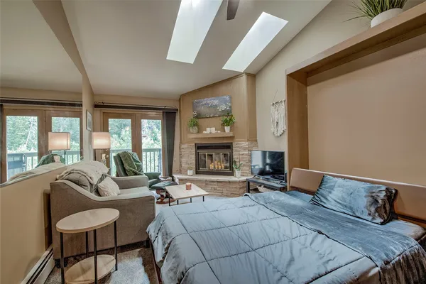 a bedroom with furniture large window and fireplace