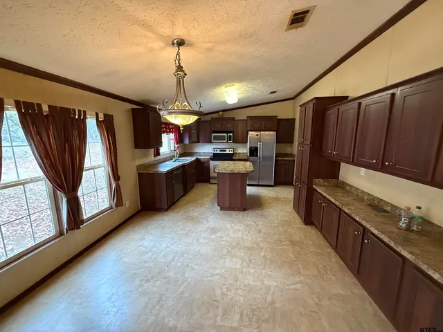 a view of a kitchen with stainless steel appliances granite countertop a refrigerator and a sink