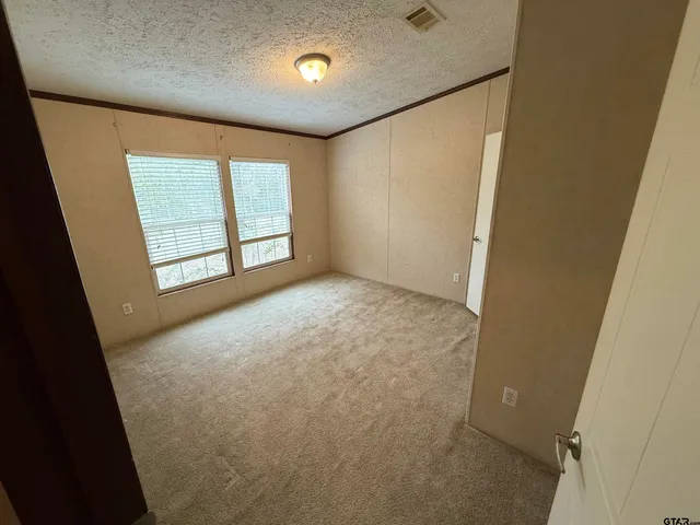 an empty room with windows and closet
