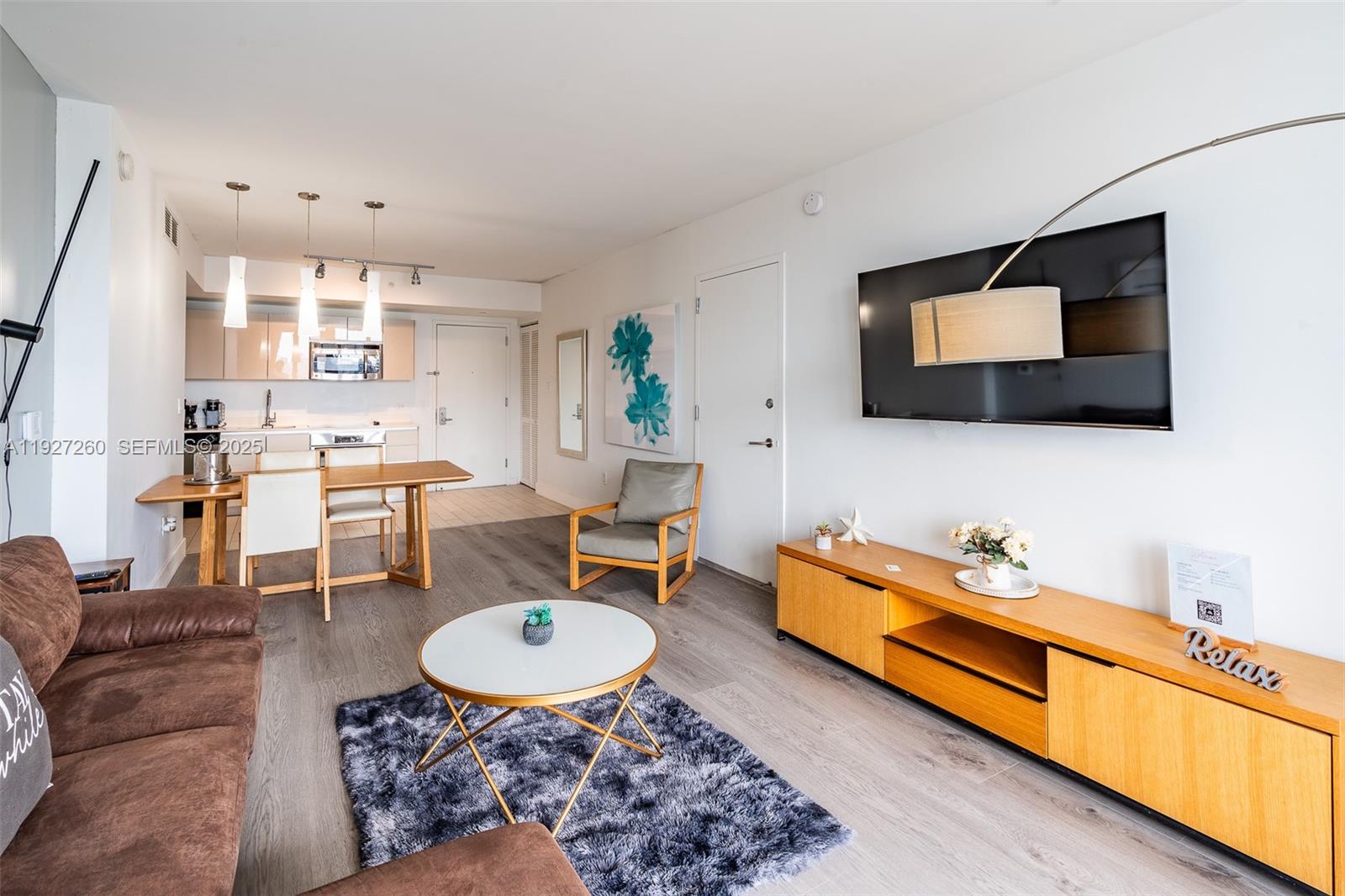 2602 East Hallandale Beach Boulevard, Unit R809 Hallandale Beach, FL 33009 - Photo 1 of 41 a living room with furniture a flat screen tv and kitchen view