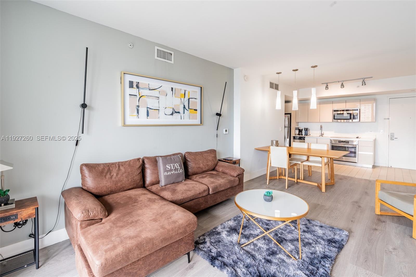 2602 East Hallandale Beach Boulevard, Unit R809 Hallandale Beach, FL 33009 - Photo 3 of 41 a living room with furniture a rug and a table