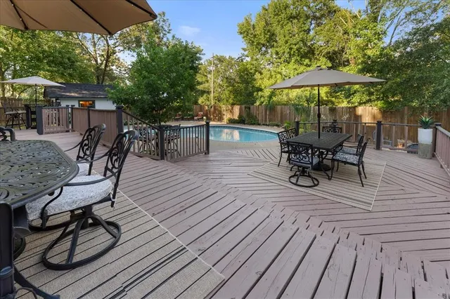a view of a roof deck with table and chairs under an umbrella with wooden floor