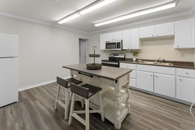 a kitchen with a sink cabinets and wooden floor