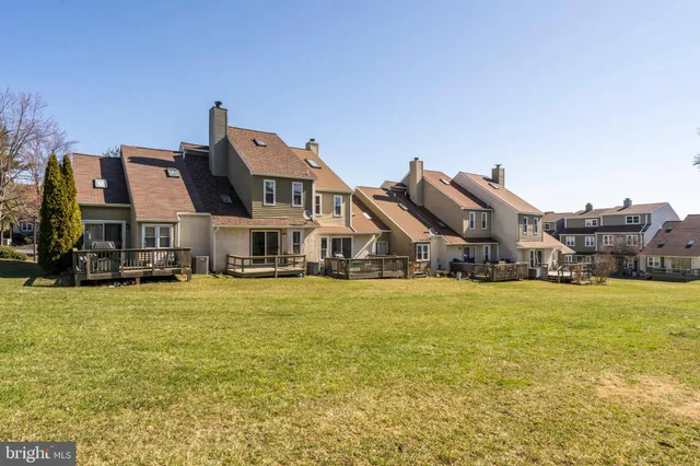 a front view of a house with a big yard and large trees