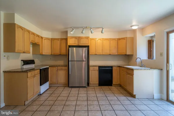 a kitchen with a refrigerator sink and cabinets
