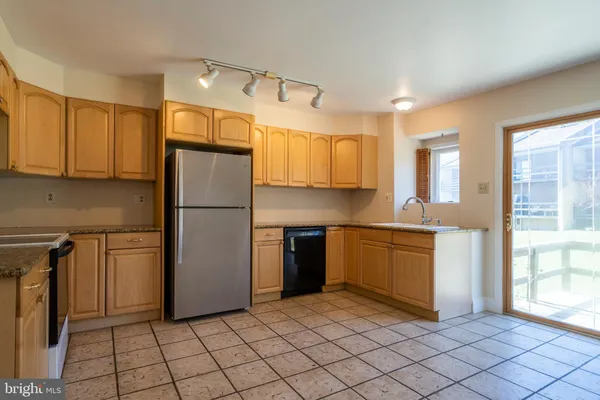 a kitchen with a refrigerator a stove top oven and cabinets