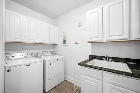 a kitchen with white cabinets and window