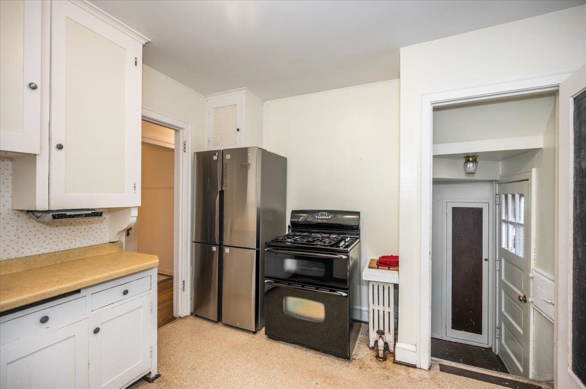 2202 Missouri Avenue Superior, WI 54880 - Photo 9 of 24 Kitchen featuring range with two ovens, white cabinets, light countertops, freestanding refrigerator, and radiator