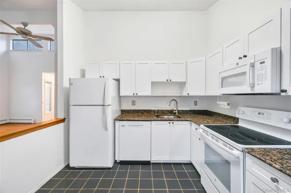 a kitchen with a white cabinets and white appliances