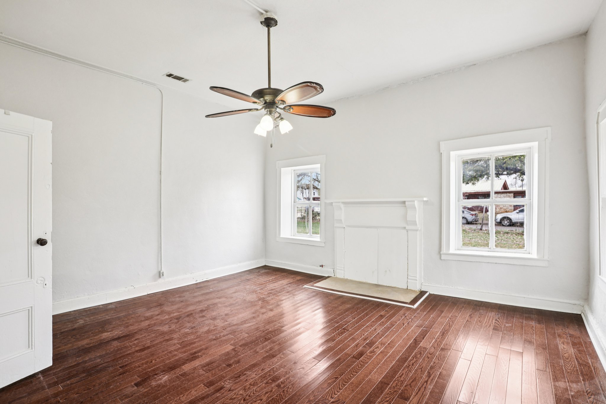 1801 Candee Street Georgetown, TX 78626 - Photo 10 of 14 an empty room with wooden floor chandelier fan and windows