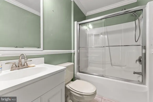 a bathroom with a sink a mirror toilet and shower