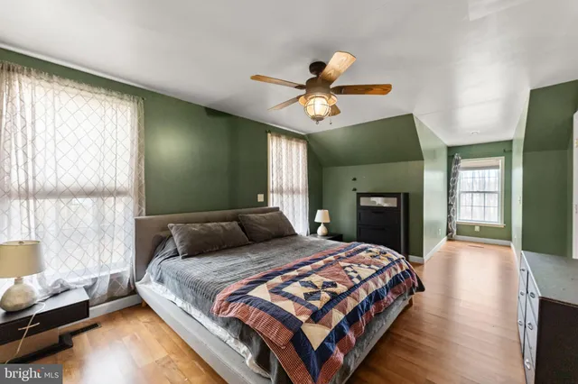 a bedroom with a bed ceiling fan and a window
