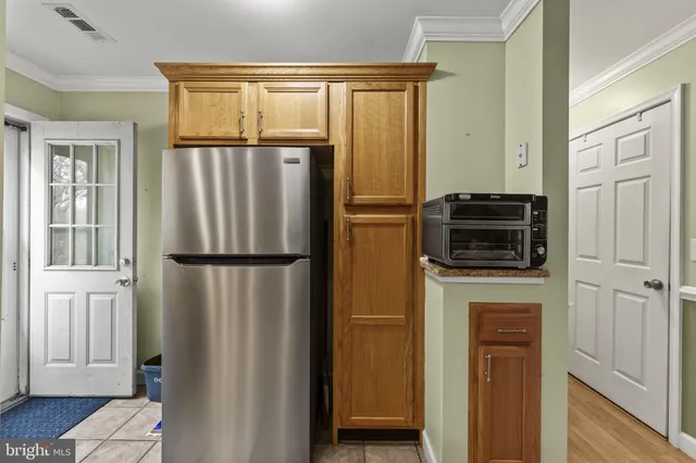 a kitchen with a refrigerator and a stove top oven