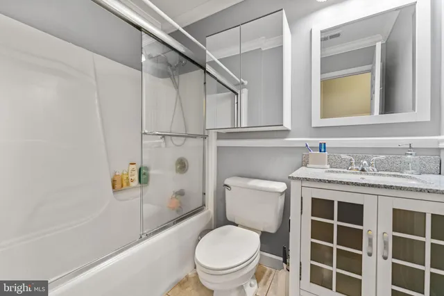 a bathroom with a granite countertop toilet sink and mirror