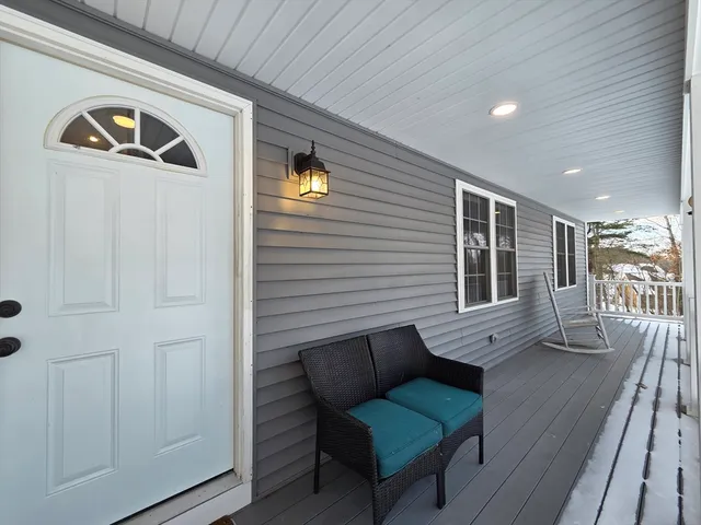 a view of a porch with furniture and wooden floor