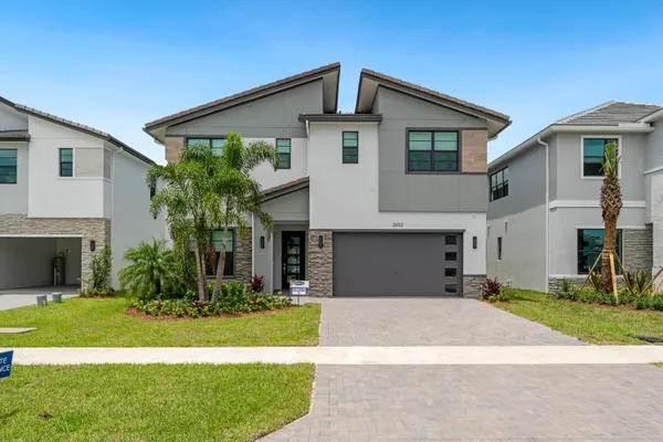 a front view of a house with a yard and garage